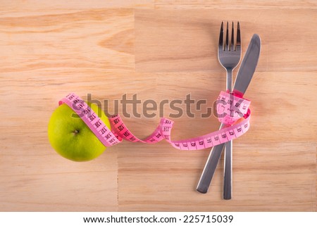 Diet. Dieting Concept. Diet Menu. Plate with measure tape, cup, knife and fork. Diet food on wooden table