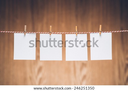 Blank photo frames hanging on the clothesline . Isolated on wooden background. Vintage style.