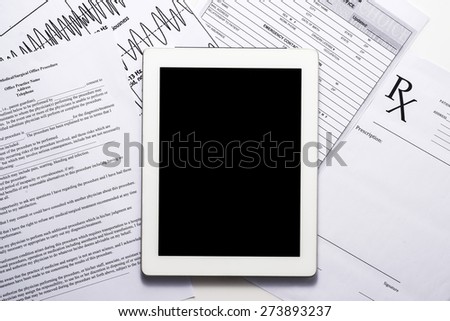 Modern digital tablet with paperwork at the desktop. Medicine concept. View from above