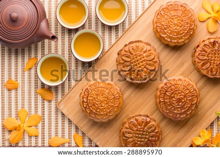 Chinese mid autumn festival foods. Traditional mooncakes on table setting with teapot.