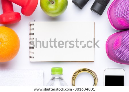 Flat lay of Sport equipment. Sneakers, dumbbells, water, towel, fruits and phone on white background. Notebook with copyspace. View from above