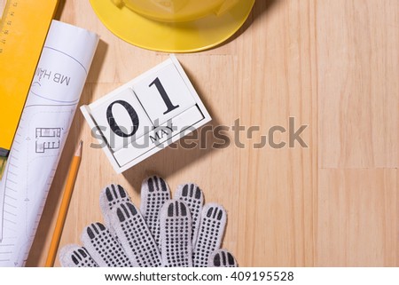 May 1st. Image of may 1 white blocks wooden calendar with construction tools on the table. International Workers' Day. Labor day concept. Copy space view from above