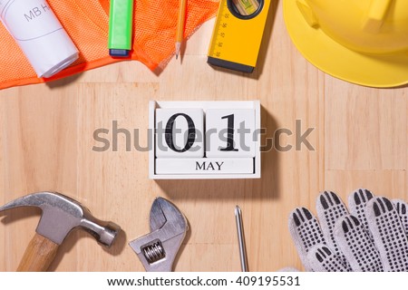 May 1st. Image of may 1 white blocks wooden calendar with construction tools on the table. International Workers' Day. Labor day concept.