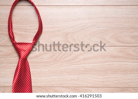 Happy Fathers Day gift tag with red striped necktie on rustic wood background