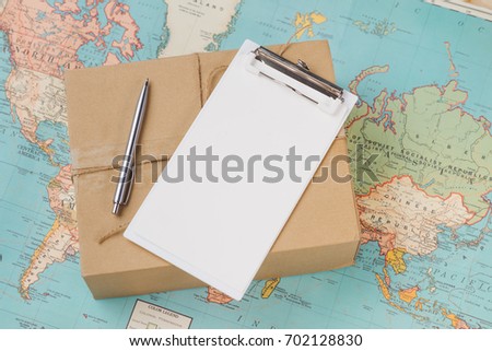International shipping. Cardboard box on the geographical map background
