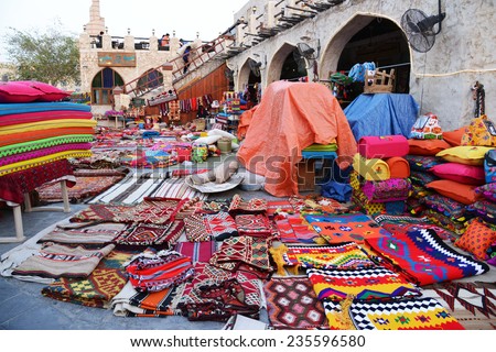 QATAR, DOHA - March 20 2014: Souq Waqif is a main marketplace selling traditional garments, spices, handicrafts, and souvenirs. Colorful garments at the shop in front of Asherg Coffee..