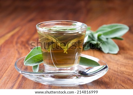 hot sage tea with fresh sage, silver spoon, wooden floor,
