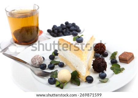 cheese cake decorated with mint, chocolate and blue berries, and herbal teal on white background