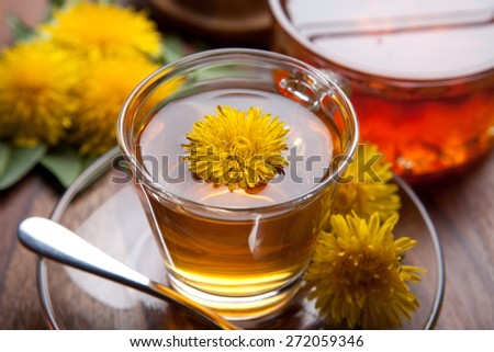 dandelion herbal tea on wooden table, with honey, fresh yellow blossoms