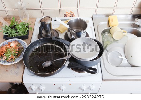 messy kitchen in domestic household, with dirty pan and pots on stove, leftovers and grungy tableware,