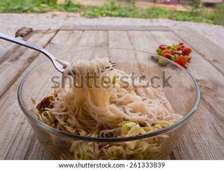 Thai vermicelli eaten with curry and vegetable on old wood table,Thai vermicelli eaten with curry,noodle,boiled Thai rice vermicelli, usually eaten with curries or Thai style