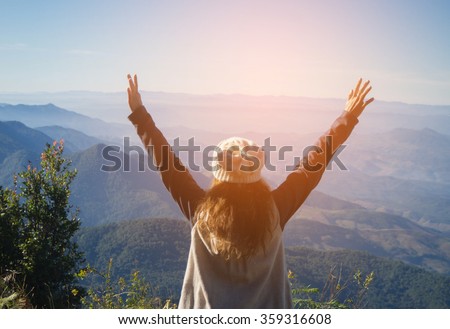 Young Woman standing alone outdoor with wild forest mountains on background Travel Lifestyle and survival concept rear view