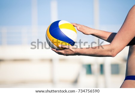 Beach volleyball player, playing summer. Woman with ball. A woman body holding a beach volley ball in hand.