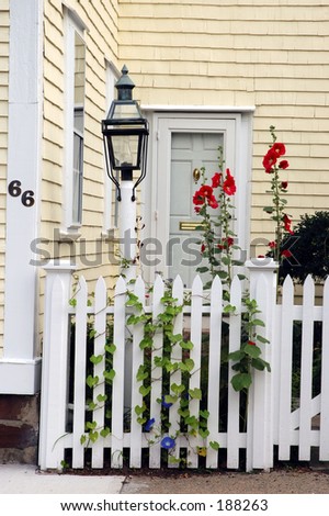 Colonial house entranve with front fence and small garden