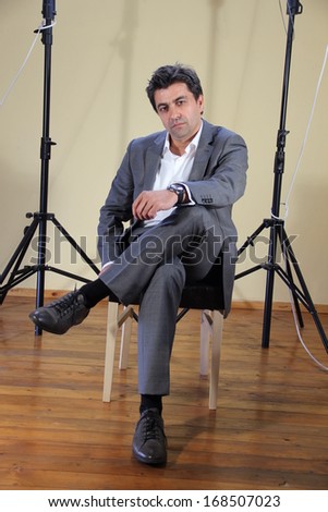 man in gray suit in front of the studio lights
