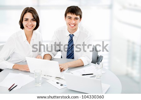 Portrait of attractive smiling business woman, team in background