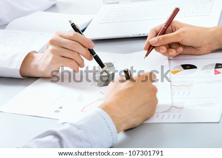 Close-up of businessman explaining a financial plan to colleagues at meeting