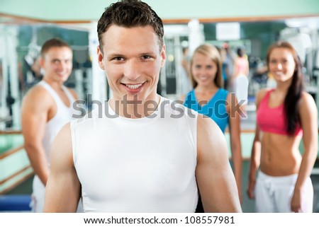 Young fitness instructor with gym people