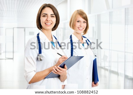 Portrait of two successful female doctors holding a writing pad