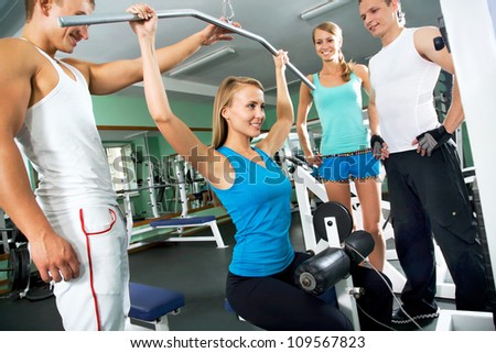 Fitness. Woman at the gym doing arms exercises on a machine