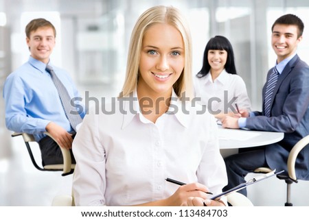 Portrait of a smiling young attractive business woman in a meeting .