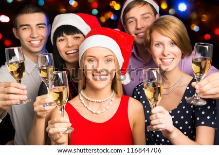 Portrait of smart colleagues with flutes of champagne wishing you Merry Christmas