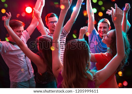 Group of happy young people having fun dancing at party.