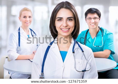 Portrait of a smart female doctor sitting in front of his team and smiling