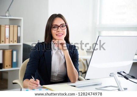 Young beautiful business woman with computer in an office