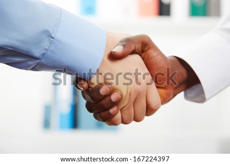 Businessmen shaking hands while in their office
