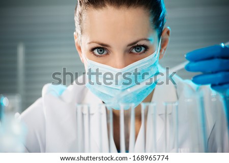 Attractive young scientist observing the blue indicator color shift in the glass tube