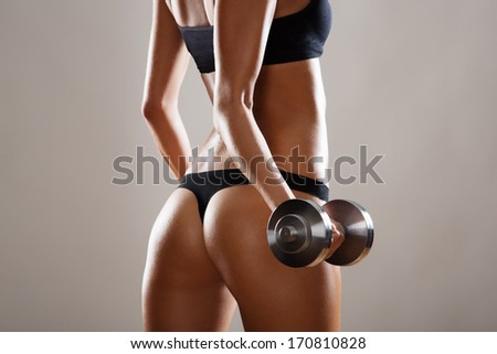 Fitness woman. Slim woman with dumbbells.