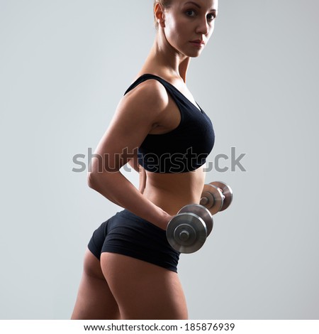 Fitness woman. Slim woman with dumbbells.
