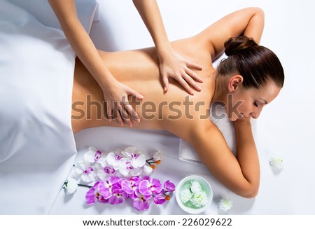 Masseur doing massage on woman face in the spa salon. Beauty treatment concept.