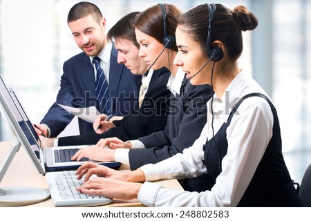 Team of people working with headsets on in a call center