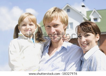 Portrait of happy husband, wife and their daughter somewhere outside
