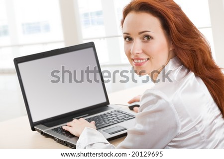 Portrait of beautiful secretary while typing on the laptop