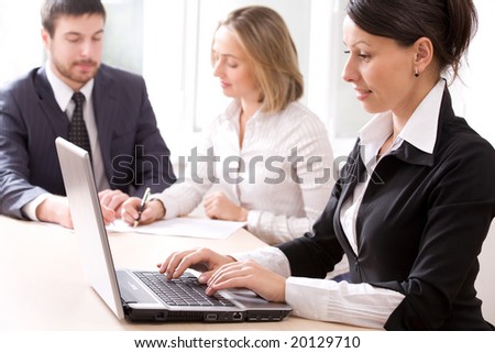 Image of businesswoman typing a letter on the background of people