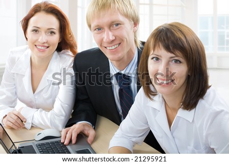 Three business people sit at the table