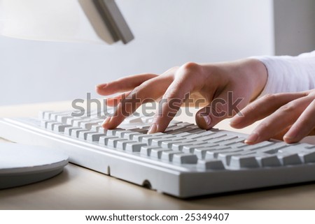 Close-up of hands touching computer keys during work