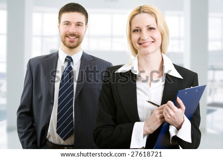Portrait of two happy business people standing together in office