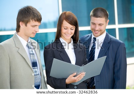 The business people signs the agreement on a background of a building