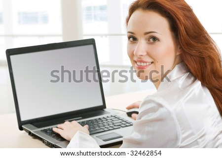 Portrait of beautiful secretary while typing on the laptop