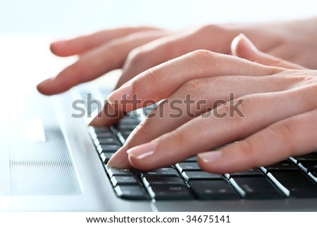 Close-up of female fingers typing a business document on the laptop