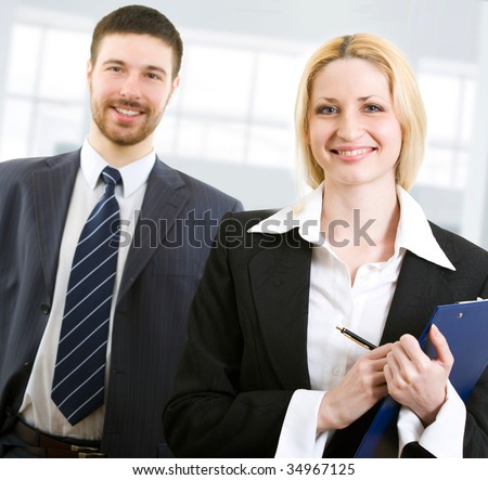Portrait of two happy business people standing together in office