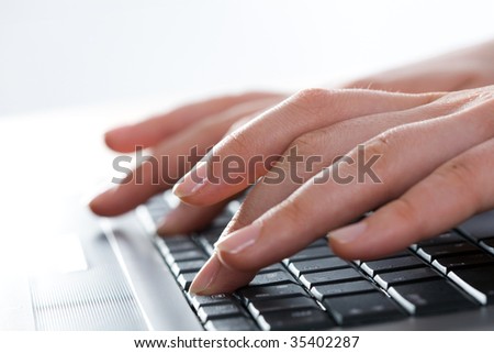 Close-up of female fingers typing a business document on the laptop