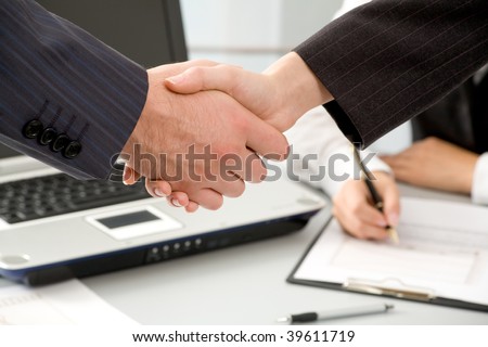 Close-up of hands shake between two successful business people: man and woman