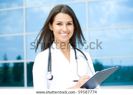 Young female doctor stand against a hospital building