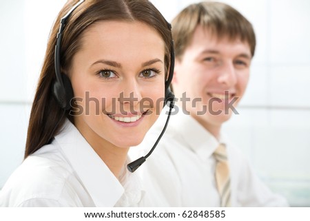 Portrait of beautiful telephone operator  looking at camera in working environment