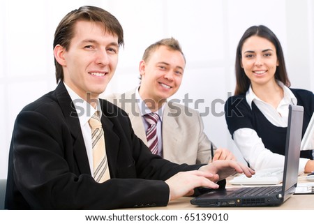Image of three business people working at meeting